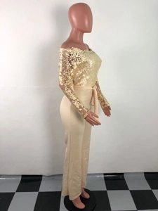 Detailed close-up of beige lace embroidery and waist belt on off-shoulder jumpsuit