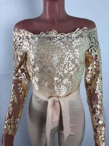 Detailed champagne lace off-shoulder romper with elegant floral patterns and waist ribbon tie