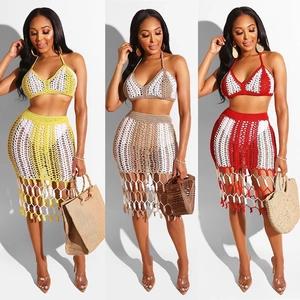 Detail of crochet two-piece beach set featuring halter top and fringe hollow skirt