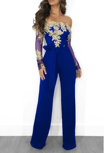 Detail of royal blue jumpsuit featuring gold lace embroidery and sheer long sleeves