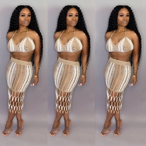 Detailed view of beige and white crochet knit bikini top and fringe skirt set for beach wear