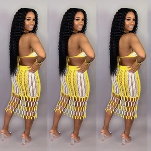 Detail of crochet knit beach set featuring yellow contrast top and fringe hollow skirt