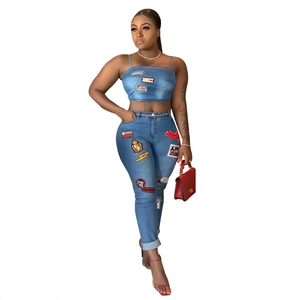 Two-piece denim set with crop top and patchwork jeans featuring retro embroidery patches