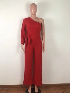 Detail of red one-shoulder jumpsuit with single long sleeve and waist tie belt