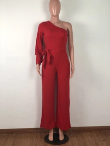 Detail of red one-shoulder jumpsuit featuring a waist bow and wide-leg trousers design