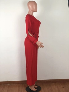 Detail of red one-shoulder jumpsuit with waist tie and side slit on high-waist straight leg
