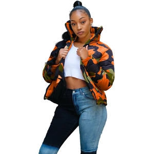 Detail of colorful camo puffer jacket with high collar and patchwork denim jeans