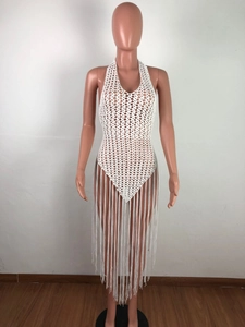 Detail of white crochet knit halter top featuring hollow out patterns and long fringe tassels