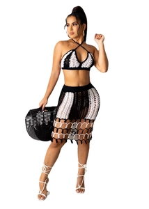 Detail of two-piece crochet black and white beach set with halter top and hollow midi skirt