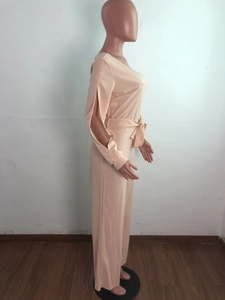 Detail of apricot jumpsuit showing V-neck design and stylish side-slit long sleeves