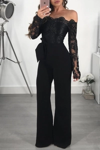 Close-up of black off-shoulder jumpsuit with intricate floral lace and bow waist belt