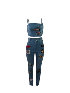 Detail of light blue denim two-piece set featuring vintage street style embroidered patches