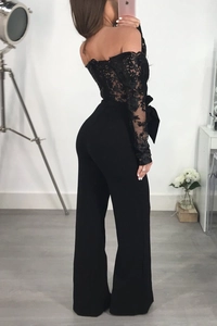 Detailed back view of lace off-the-shoulder jumpsuit with black ribbon waist bow tie