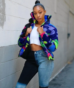 Close-up of vibrant camouflage puffer jacket with purple and neon green patchwork details