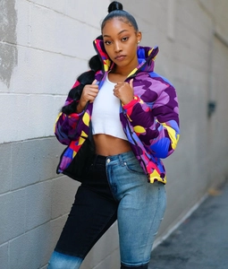 Detailed view of colorful camouflage puffer jacket with high collar and vibrant street style