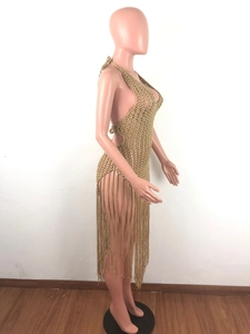 Detail of the golden crochet knit beach dress featuring long fringe and openwork texture