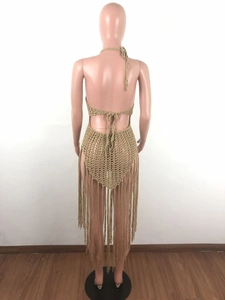 Macro detail of the bohemian crochet knit texture and long fringe hem on the back dress