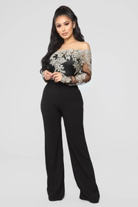 Detail of elegant black off-shoulder jumpsuit featuring silver lace floral embroidery details