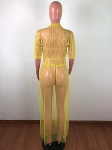 Detail of sheer yellow mesh dress showing ruffled collar and textured ruching details