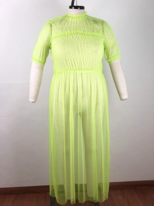 Macro detail of fluorescent green pleated mesh fabric with ruffle hem and sheer texture