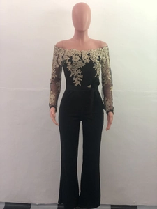 Detail of elegant black off-shoulder jumpsuit featuring gold floral lace and mesh sleeves