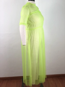 Detail of neon green sheer mesh dress showing ruffled texture and pleated long skirt