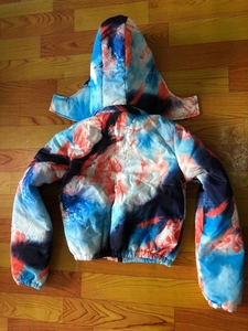 Detail of hooded puffer jacket with abstract blue and orange graffiti print and elastic cuffs