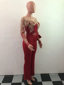 Close-up of red off-shoulder jumpsuit featuring intricate gold lace floral embroidery