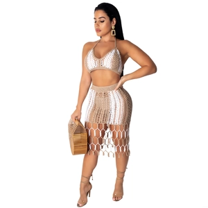 Bohemian two-piece crochet set with halter crop top and tassel midi skirt in earth tones