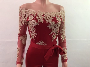 Close-up of golden lace embroidery on the bodice of a dark red off-shoulder jumpsuit