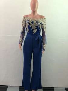 Detail of navy blue off-shoulder jumpsuit featuring gold floral lace and wide leg cut