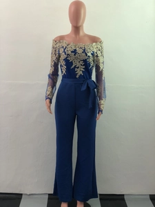 Detail of navy blue wide leg jumpsuit with gold lace embroidery and off-shoulder neckline