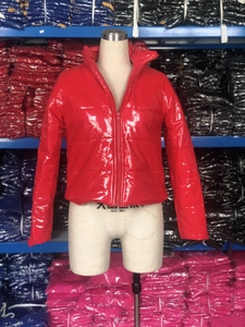 Détail de la doudoune en cuir PU rouge brillant avec finition laquée et col montant