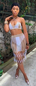 Detail of crochet knit texture with fringe hem and color-block pattern on beach skirt