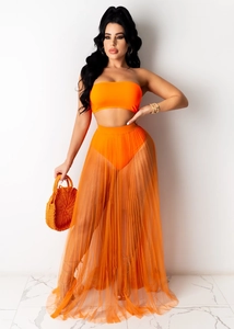 Detalle de falda playera de malla naranja transparente con textura plisada y top a juego