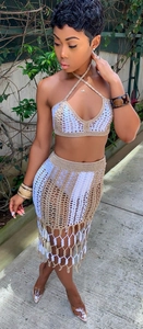 Detail of bohemian crochet two-piece set featuring beige knit texture and tassel hem