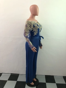 Detailed side view of navy jumpsuit featuring gold lace embroidery and satin waist belt