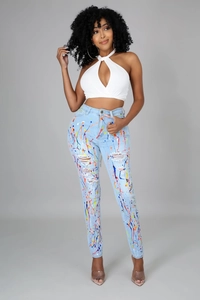 Dettaglio dei jeans azzurri strappati con vivaci accenti di schizzi di vernice colorata