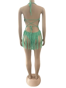 Detail of mint green crochet beach dress featuring a backless tie design and long fringes