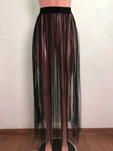 Detalle de la cintura elástica y el tejido de malla transparente en la falda larga negra