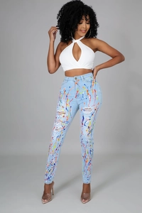 Dettaglio di jeans a vita alta blu chiaro consumati con schizzi di vernice colorati