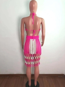 Close-up back view of boho crochet beach set with pink halter top and striped fringed skirt