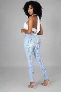 Dettaglio dei jeans skinny blu con schizzi di vernice colorati e design attillato