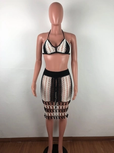Detail of crochet knit two-piece set featuring black and white halter top and mesh skirt