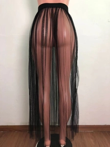 Detalle de falda larga de playa en malla negra transparente con cintura elástica ancha