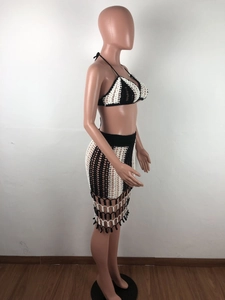 Close-up of black and white crochet two-piece beach set with fringe details and knit texture