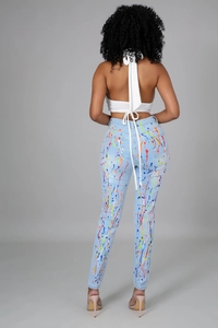 Dettaglio di spruzzi di vernice colorata su jeans slim azzurri con vista posteriore