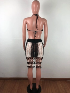 Detail of bohemian black and white crochet knit two-piece set with fringe and openwork design