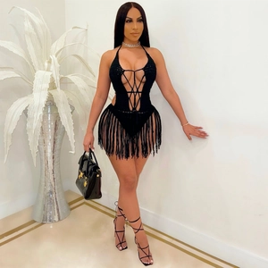Detail of black crochet halter bodysuit with criss-cross ties and long fringe tassels