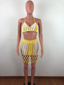 Detail of yellow and white crochet two-piece beach set showing knit texture and hollow hem